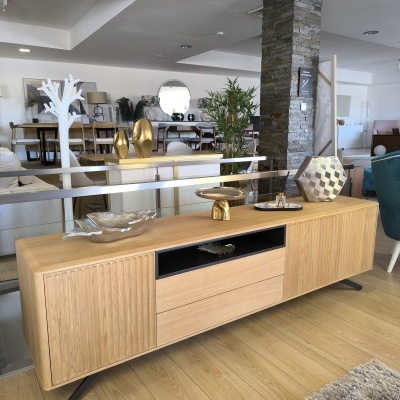 Móvel de madeira clara com decoração metálica num interior moderno