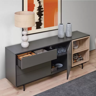 Aparador cinza escuro e natural com gavetas e porta abertas, candeeiro branco e vasos cinzentos em cima, quadro abstrato atrás