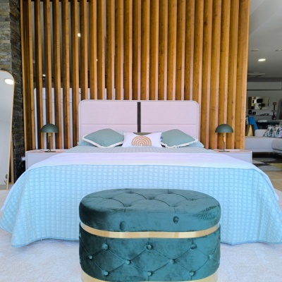 Quarto com cama de cabeceira almofadada bege e colcha azul clara