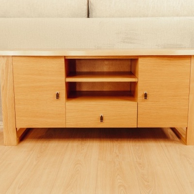 Aparador em madeira clara com portas e gaveta num ambiente interior