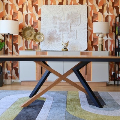 Mesa de madeira com pernas cruzadas e decoração interior com papel de parede geométrico