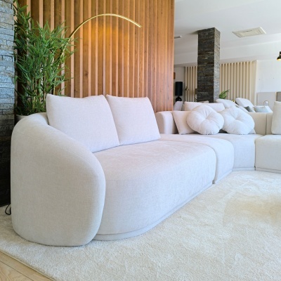 Sofá de tecido beige claro com almofadas numa sala moderna