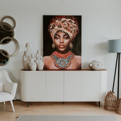 Sala de estar moderna com móvel branco, quadro de mulher com turbante, espelhos redondos e abajur cinza