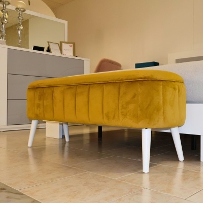 Banco amarelo estofado em veludo com pernas brancas