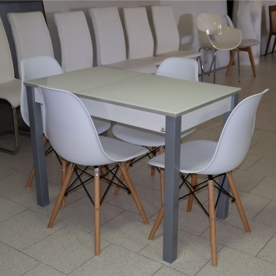 Mesa de jantar branca com quatro cadeiras brancas em ambiente interno