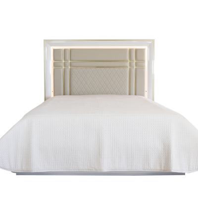 Cama bege com cabeceira detalhada e roupa de cama branca texturizada