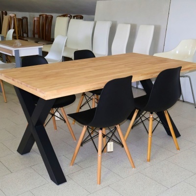 Conjunto de mesa com tampo de madeira clara e quatro cadeiras pretas com pernas de madeira