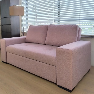 Sofá rosa claro de tecido com duas almofadas em sala com janela e lâmpada