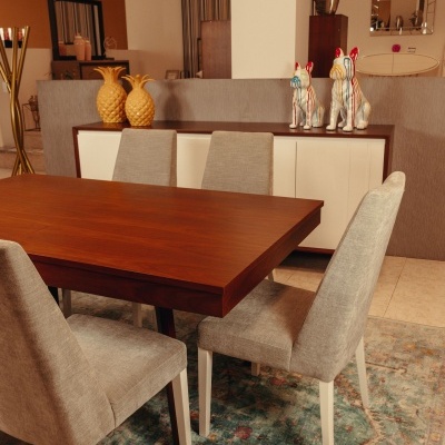 Conjunto de sala de jantar com mesa de madeira, cadeiras cinza e aparador com decoração