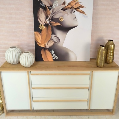 Móvel branco e madeira com decoração de vasos e quadro de mulher com folhas