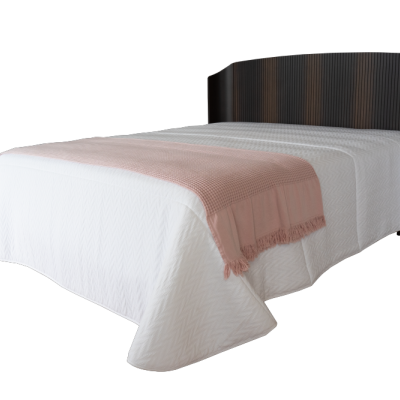 Cama com roupa branca e manta rosa e cabeceira escura