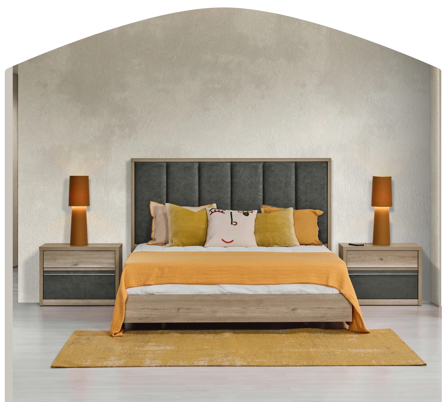 Quarto com cama de madeira e cabeceira cinzenta, roupa de cama laranja e branca, almofadas coloridas, mesas de cabeceira e lâmpadas laranja.