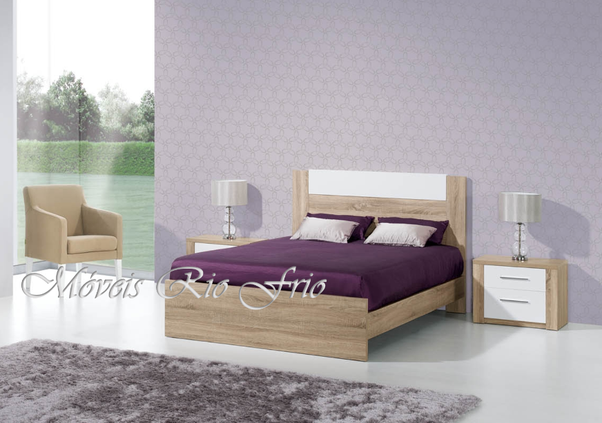 Quarto com cama de casal de madeira clara e detalhes brancos, tapete cinzento e poltrona bege.