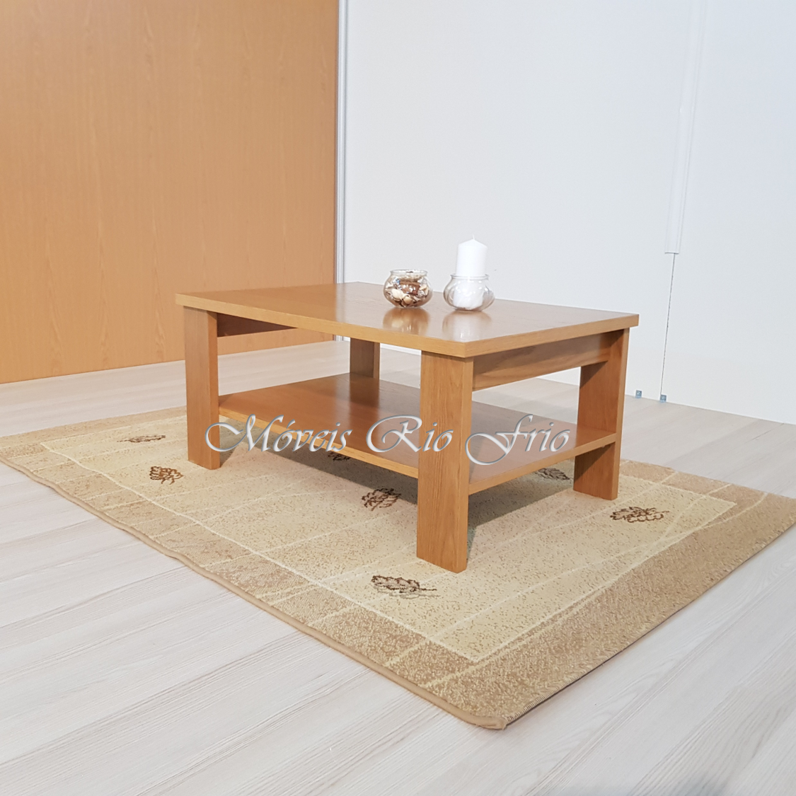 Mesa de centro em madeira clara sobre tapete bege com padrão floral marrom