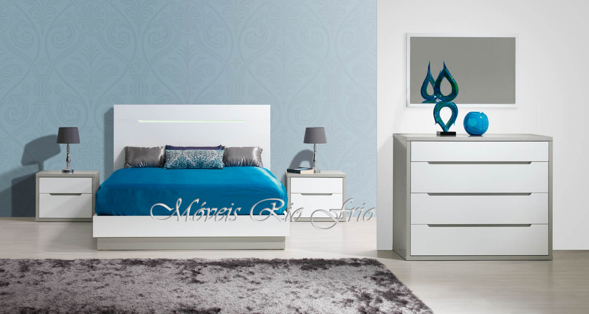 Quarto moderno com cama de casal branca, roupa de cama azul e móveis brancos