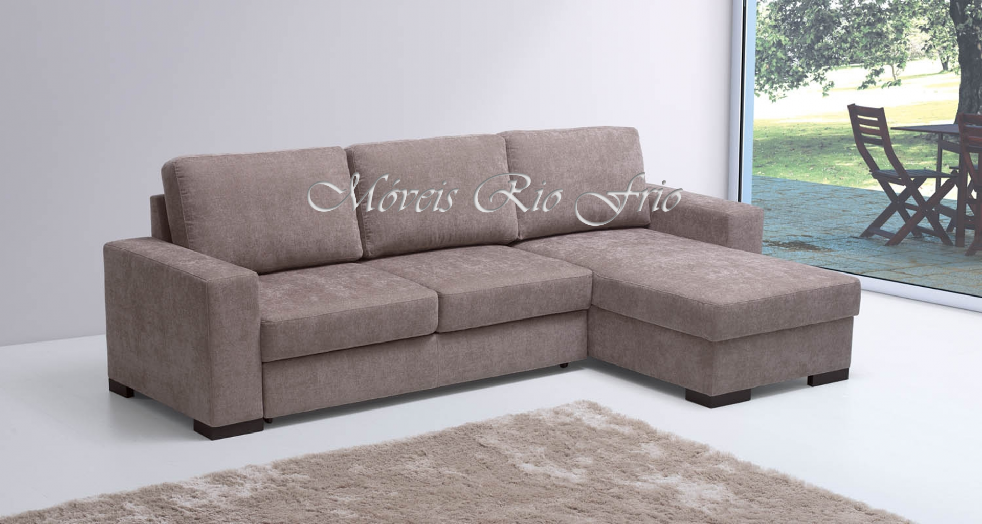 Sofá-cama de canto castanho em sala com tapete bege e janela para jardim