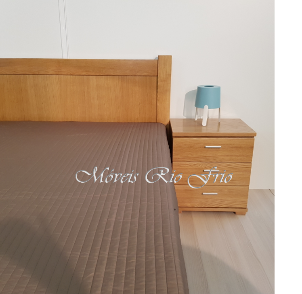 Cama de madeira com colcha castanha e mesa de cabeceira com candeeiro azul