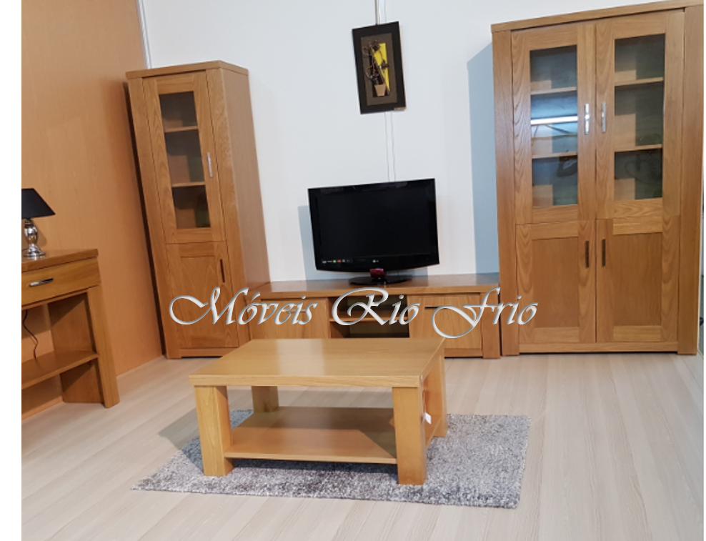 Conjunto de móveis em madeira clara com duas vitrines, mesa de centro, cómoda e televisor preto na parede