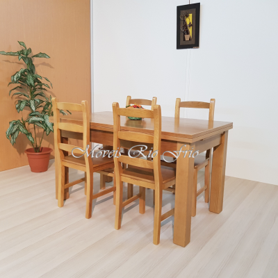 Mesa de jantar retangular em madeira clara com quatro cadeiras de madeira, planta em vaso e quadro pendurado na parede branca.