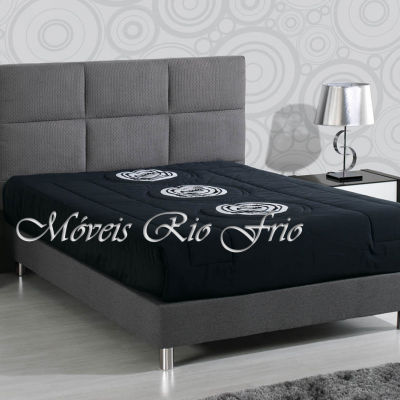 Cama de casal cinza com colchão preto estampado e mesas de cabeceira com candeeiros