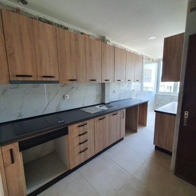 Cozinha com armários de madeira clara e bancada preta