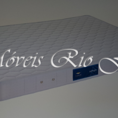 Colchão branco acolchoado com etiqueta azul e texto sobreposto 'Móveis Rio Frio'