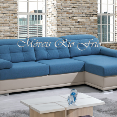 Sofá de canto azul com estrutura bege em sala moderna com parede de tijolos e janela