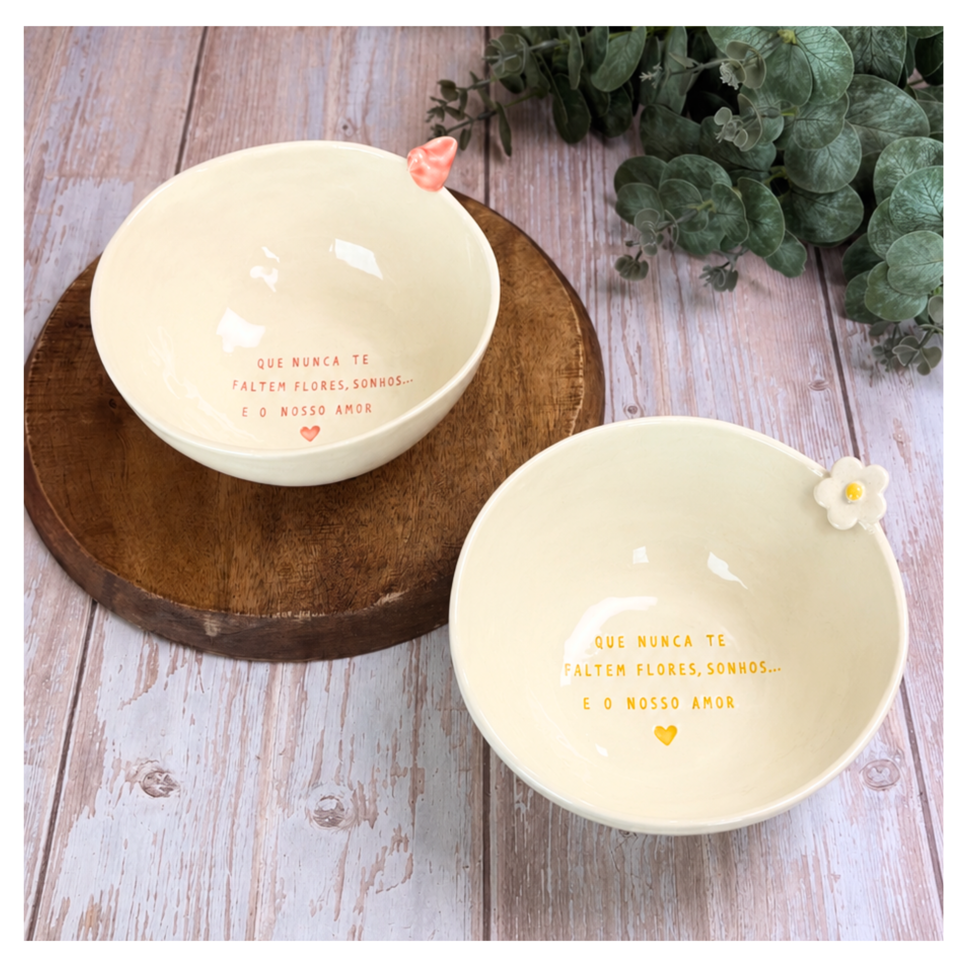 Taça Grande Personalizada Duas tigelas de cerâmica creme com texto interior, na base de madeira, com plantas verdes ao fundo