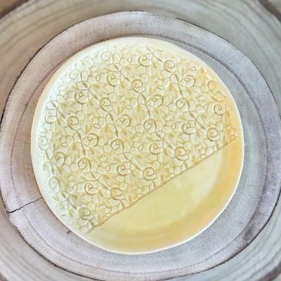 Prato de cerâmica texturizado com padrão floral e acabamento liso amarelo