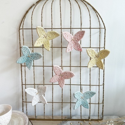 treliça metálica decorativa com borboletas coloridas em pastel