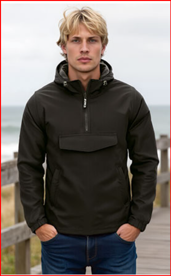 Casaco Anorak com capuz e meio fecho. Homem com casaco preto de capuz e calças jeans azuis numa passadeira junto ao mar