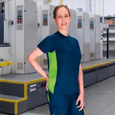 Roupa de trabalho azul escuro com painéis verdes em ambiente de fábrica