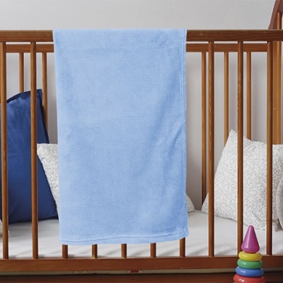 Berço de madeira com cobertor azul e almofadas dentro