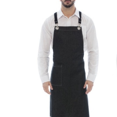 Homem com avental preto, camisa branca e calças pretas.