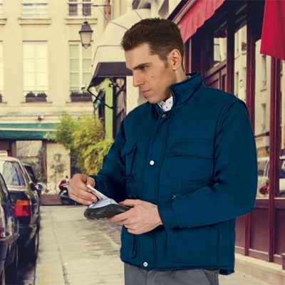 Homem com casaco acolchoado azul a usar máquina de pagamento na rua