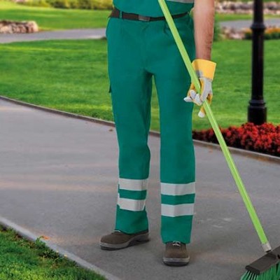 Homem a varrer passeio em parque com calças verdes e vassoura verde