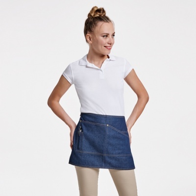 Mulher com polo branco e saia tipo avental em ganga azul