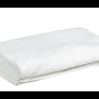 Toalha branca dobrada com padrão em relevo numa extremidade