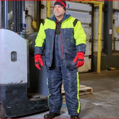 Homem com roupa de proteção amarela e cinza em ambiente industrial