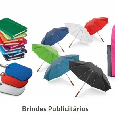 Brindes publicitários variados incluindo pincéis, blocos de notas, porta-chaves, guarda-chuvas e sacos de tecido coloridos