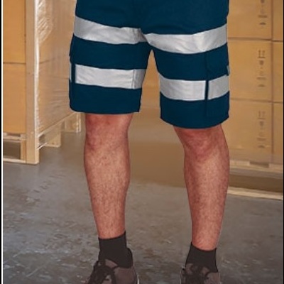 Calções de trabalho azuis escuros com faixas refletoras cinza em ambiente de armazém.