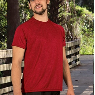 Homem a usar camisola vermelha de manga curta e calções pretos num passadiço de madeira ao ar livre.