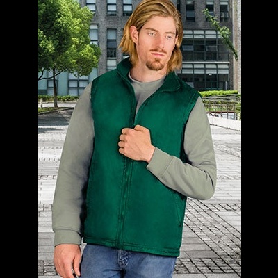 Homem com colete verde escuro felpudo, manga cinza clara e jeans azul em ambiente urbano