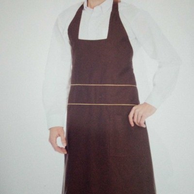 Homem com avental castanho escuro e camisa branca com fundo branco