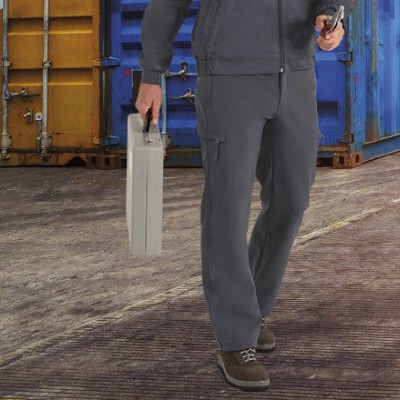 Pessoa com roupa de trabalho cinzenta e mala metálica prateada num espaço industrial