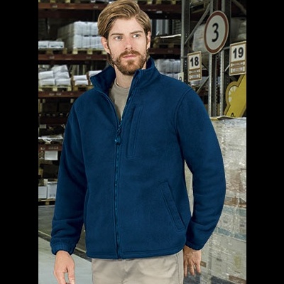 Homem com casaco polar azul escuro num armazém com prateleiras e placas numeradas no fundo