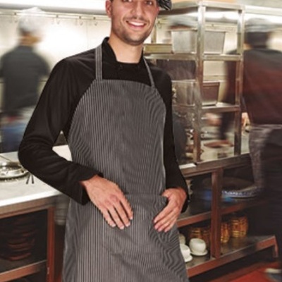 Cozinheiro com avental e chapéu cinzentos numa cozinha profissional