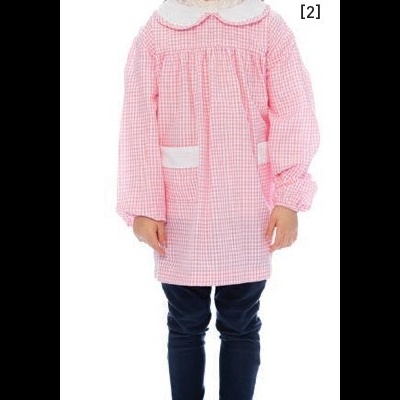 Criança com blusa rosa xadrez com gola branca e bolsos, calças escuras e sapatos pretos