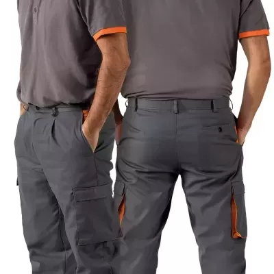 Homem com camisa polo cinzenta e calças cinzentas com detalhes laranja em fundo branco