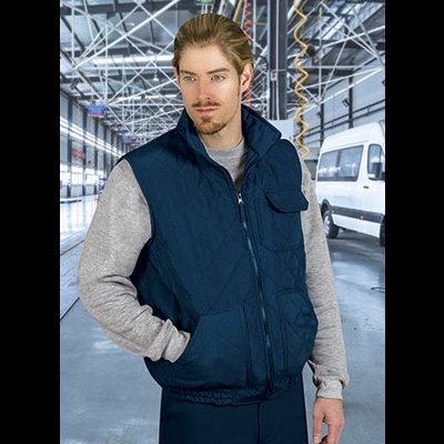 Homem com colete acolchoado azul escuro e sweatshirt cinza em armazém